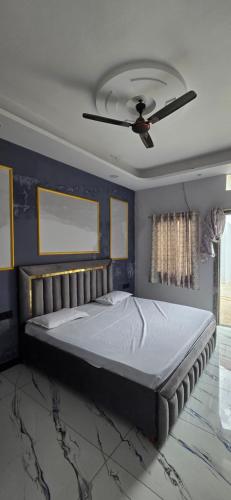 a bedroom with a large bed with a ceiling fan at Muskan home stay in Ujjain