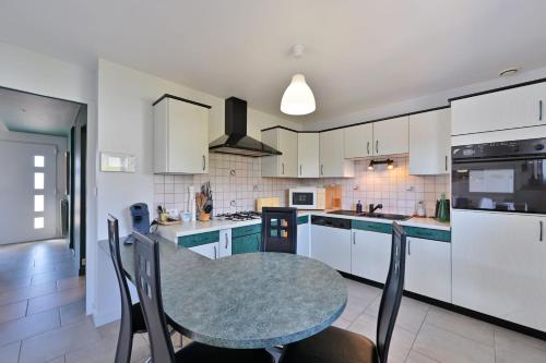 a kitchen with a table and chairs in it at Le Boucard - Terrasse - Proche plage in Saint-Nazaire