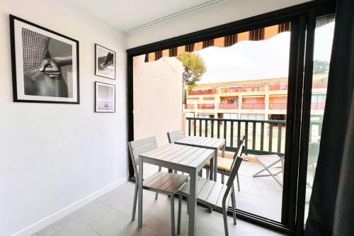 a dining room with a table and chairs on a balcony at BEACH WALK Climatisé piscineparkingproche mer in Bandol