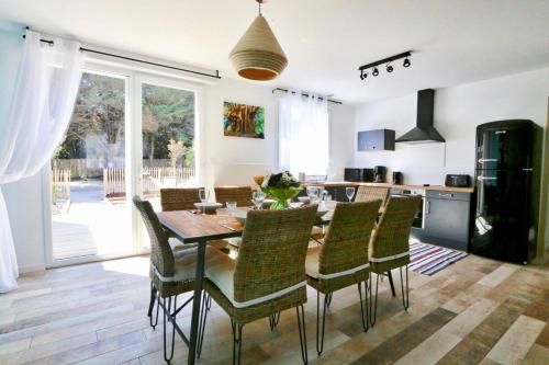 une cuisine et une salle à manger avec une table et des chaises dans l'établissement Villa Hawaï - Domaine Le Sherwood, à Notre-Dame-de-Monts