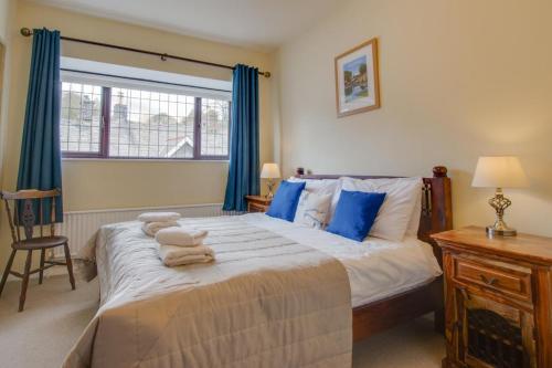 a bedroom with a large bed with blue curtains at Jaret House in Tideswell