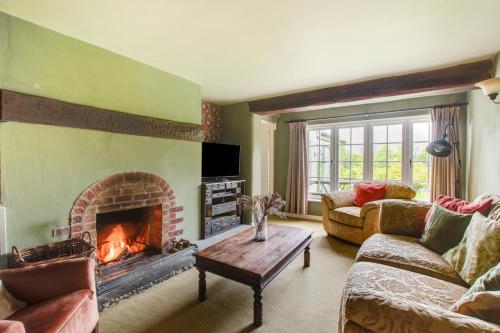 a living room with a fireplace and a couch at Woodside in Windley