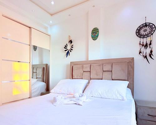 a bedroom with a bed with white sheets and a mirror at Layla Place in Tangier in Tangier