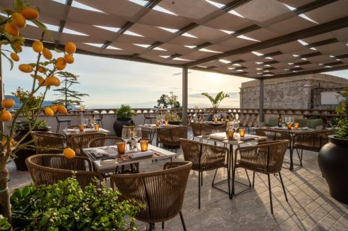 a restaurant with tables and chairs on a patio at Villa Fiorita Boutique Hotel in Taormina