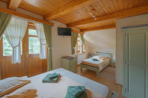 a bedroom with two beds in a room with wooden ceilings at Pensiunea Vanatorul in Băile Tuşnad