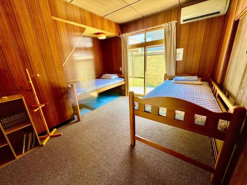 a small room with a bed and a window at 楽旅人 in Nagoya