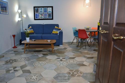 un soggiorno con divano blu e tavolo di Exclusive Suite San Biagio 25 a Napoli
