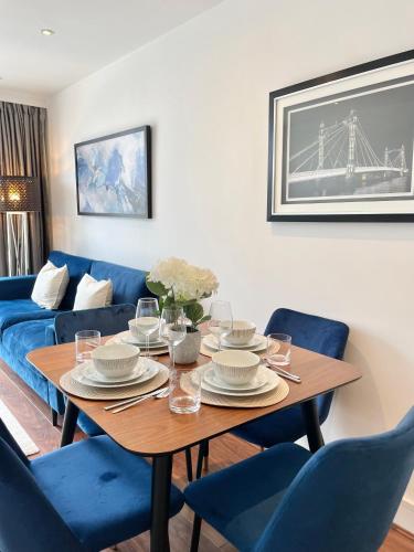 a dining room with a table and blue chairs at 2 Bed Flat next to park and Battersea Power Station in London