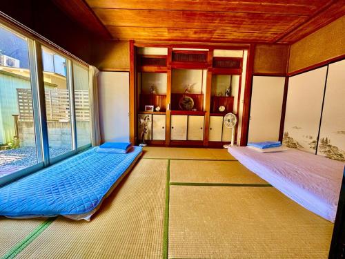 an empty room with two beds and a window at 楽旅人 in Nagoya
