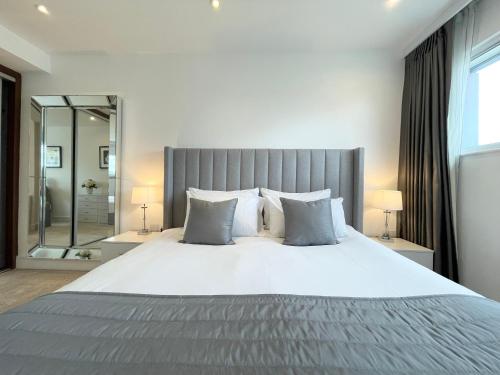 a bedroom with a large bed and a large mirror at 2 Bed Flat next to park and Battersea Power Station in London