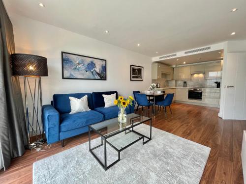 a living room with a blue couch and a table at 2 Bed Flat next to park and Battersea Power Station in London