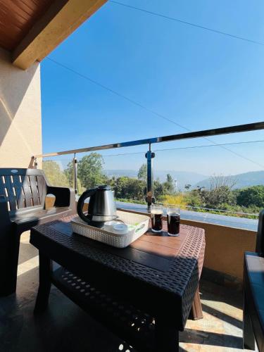 a table with a tea kettle on top of a balcony at Divine Resort- Bhilar in Panchgani
