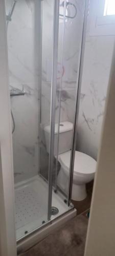 a bathroom with a toilet and a glass shower at Airport Home Tenerife Norte in La Laguna