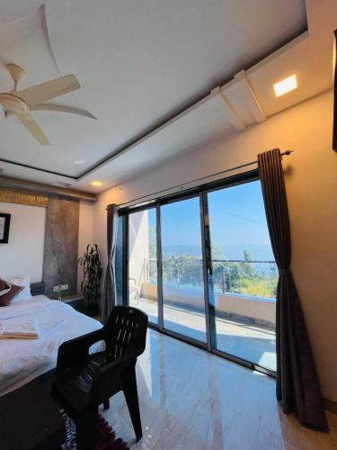 a bedroom with a bed and a large window at Divine Resort- Bhilar in Panchgani