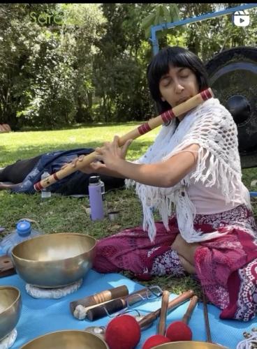 a woman is sitting on the ground holding axes at Sarayu Wellness Institute in Nairobi
