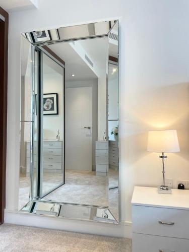 a mirror in a bathroom with a desk and a lamp at 2 Bed Flat next to park and Battersea Power Station in London