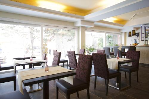 ヴァイル・アム・ラインにあるFritz Hotel & Restaurant KGのテーブルと椅子、大きな窓のあるレストラン
