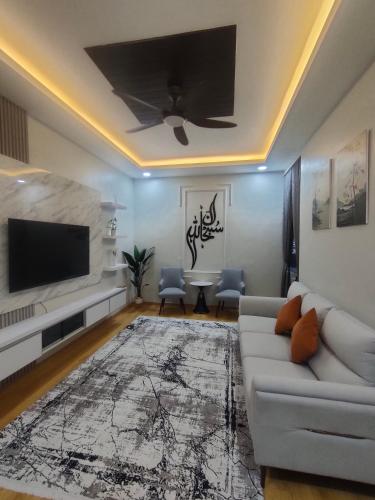 a living room with a couch and a flat screen tv at Homestay Saujana Hill in Gua Musang