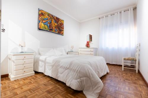 a white bedroom with a bed and a window at Blue Bay Apt - São Martinho do Porto in São Martinho do Porto