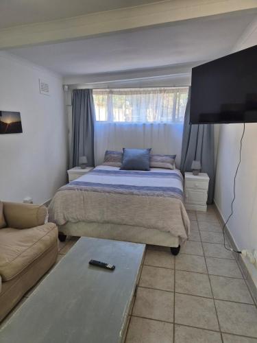 a bedroom with a bed and a flat screen tv at Ulu Garden Cottage in Ramsgate
