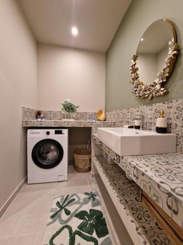 a bathroom with a washing machine and a sink at O Sole Mio in Myrties
