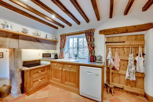 a kitchen with wooden cabinets and a white refrigerator at Wharf in Cromford