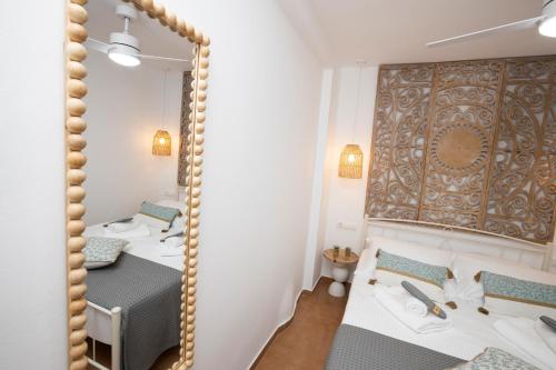 Un dormitorio con dos camas y un espejo. en Stonehill Suites Ano Syros, en Ano Syros