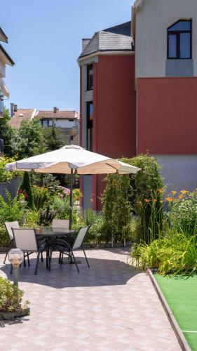 a patio with a table and an umbrella at Vermoni 21 in Chernomorets