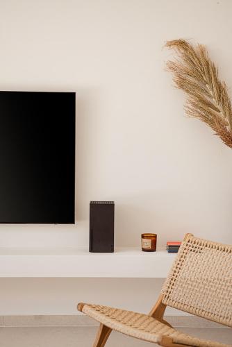 a living room with a tv and a chair at Villa Yoma- Luxury Villa with Heated Pool in Epáno Kefalás