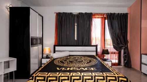 a bedroom with a black and yellow bed and a window at Vermoni 21 in Chernomorets