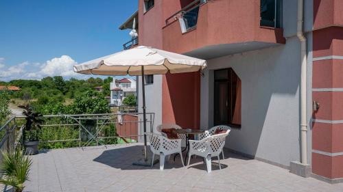 a patio with a table and an umbrella at Vermoni 21 in Chernomorets