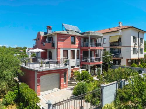 a large red house on a hill with trees at Vermoni 21 in Chernomorets