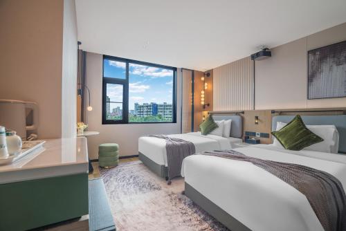 Postel nebo postele na pokoji v ubytování Kunming Spring City Boutique Hotel