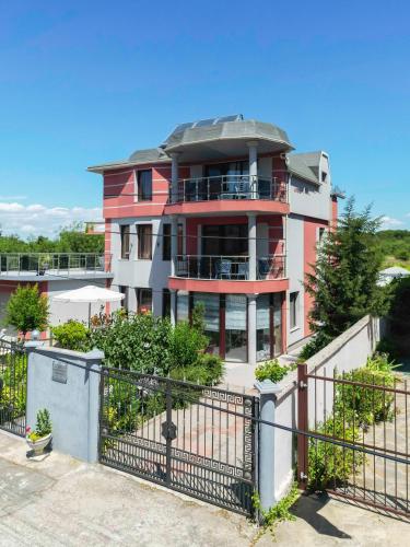 a large pink building with a fence in front of it at Vermoni 21 in Chernomorets