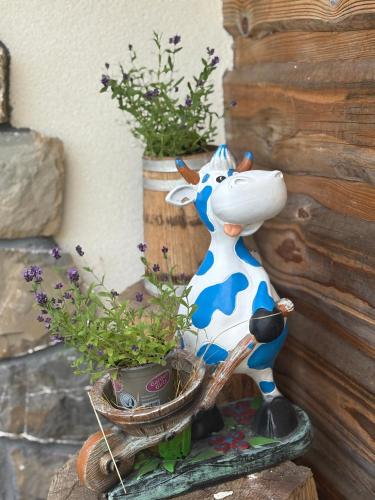 a statue of a cow next to a potted plant at Agroturystyka Na Wypasie in Grywałd