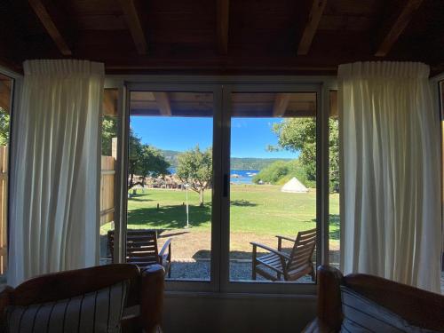a screened in porch with sliding glass doors with a view at CABAÑAS CON COSTA DE LAGO en CIRSE in San Carlos de Bariloche