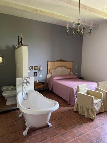 a bathroom with a bath tub and a bed at Dimora Borgo Torre in Rutino