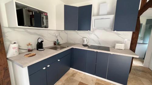 a kitchen with blue cabinets and a sink at Gîtes, Les Fontaines de Normandie in Saint-Julien-sur-Calonne