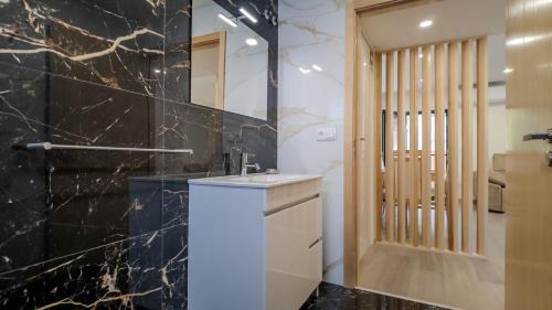 a bathroom with a sink and a black marble wall at Cantinho do Azibo 