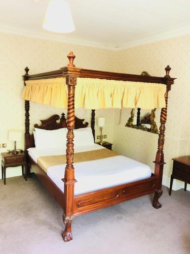 a bedroom with a canopy bed with white sheets at Albany, Brighton & Hove in Brighton & Hove