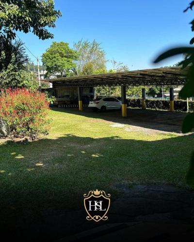 a house with a car parked in a yard at Hotel São Luiz Iraí in Iraí