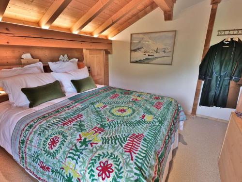 - une chambre avec un grand lit et une couette colorée dans l'établissement Chalet rénové pour 10 personnes au Chinaillon avec bain nordique - FR-1-458-218, au Grand-Bornand