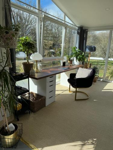 an office with a desk and a chair and windows at Forest Villa in Saint-Clair-de-Halouze