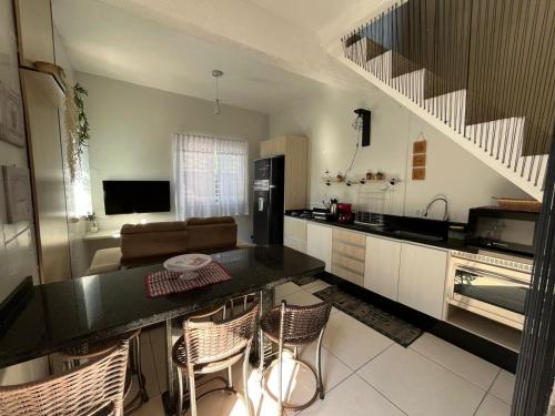 a kitchen with a counter top and a living room at Pousada Carolina Apartamentos in Penha