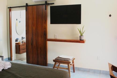 a bedroom with a bed and a tv on the wall at Casa de Alicia - Habitación Xaguar in Oaxaca City