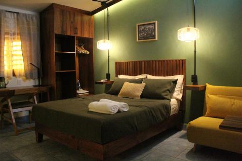 a bedroom with a bed with two towels on it at Casa de Alicia - Habitación Xaguar in Oaxaca City