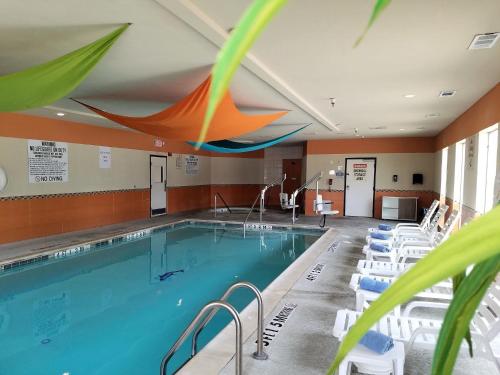 a swimming pool with lounge chairs and a large swimming pool at Holiday Inn Express & Suites Dallas East - Fair Park by IHG in Dallas