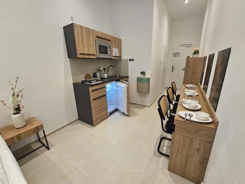 a small kitchen with a table and chairs in a room at ApartHotel Rahl 24h Self Check-in in Hamburg