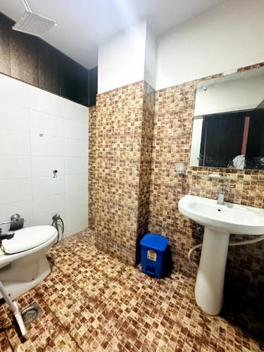 a bathroom with a sink and a toilet and a mirror at One Bed Executive Apartment in Islamabad