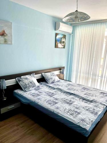 a bedroom with a bed with a blue wall at Sirena Appartment in Sveti Vlas